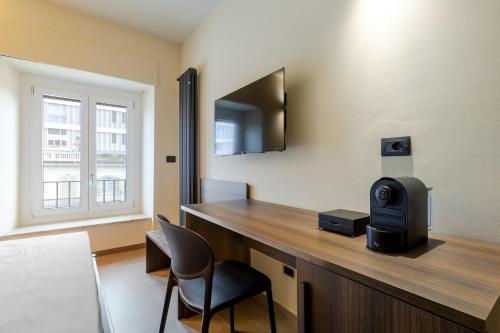 una habitación con un escritorio con televisión y una silla en SUYTE Torino Lagrange, en Turín