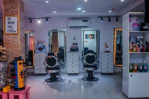 a hair salon with two barber chairs in a room at D&G Hotels & Suites in Agege