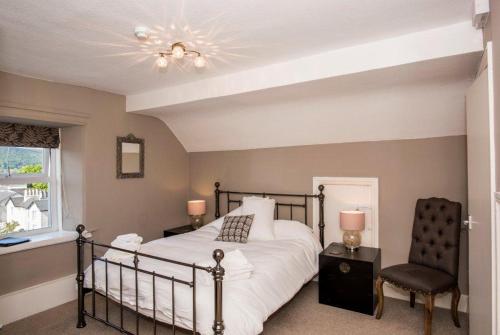 a bedroom with a bed and a chair at Baie Mooar House, Boutique B&B in Ramsey