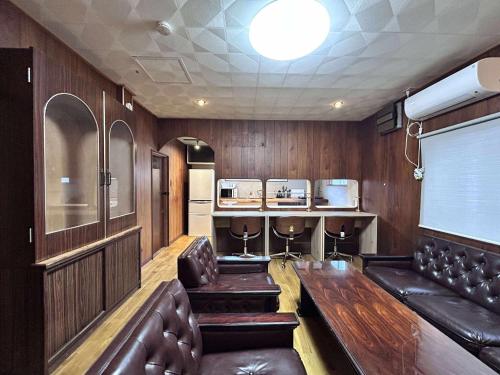 a cinema room with leather chairs and a table and a projector at ニューお染 in Kotohira