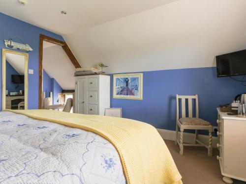 a bedroom with blue walls and a bed and a desk at Point Farm in Rye