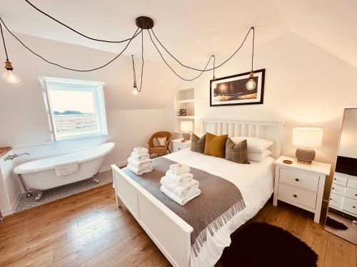 a bedroom with a bed and a tub and a sink at Kinnoull House near Stornoway Hot-Tub Sauna Pet Friendly in Garrabost