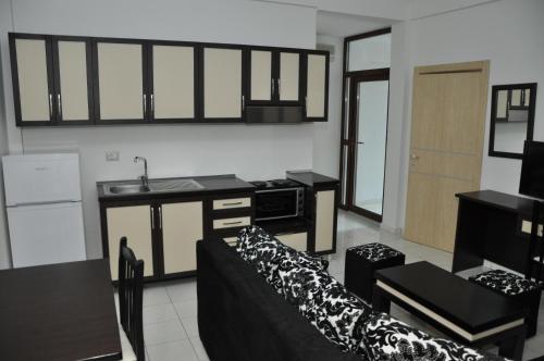 a kitchen and living room with a couch and a sink at Sunrise Hotel Cameria in Durrës