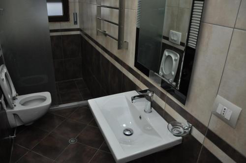 a bathroom with a sink and a toilet at Sunrise Hotel Cameria in Durrës
