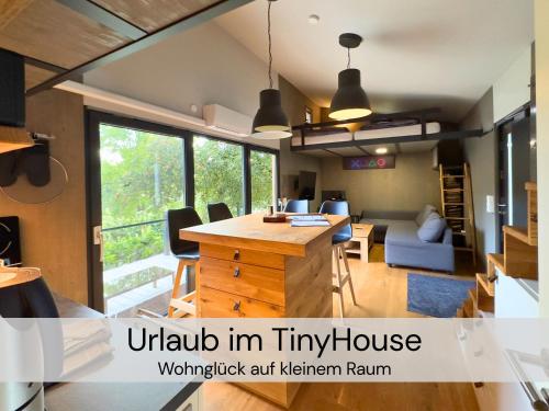 an open kitchen and living room with a large window at TinyHousebeiDresden unser größtes winziges Häuschen für bis zu 7 Personen, Kaminofen, große Terrasse - Nähe Sächsische Schweiz - Von Juni - September Mindestmietzeit 1 Woche Sa-Sa in Großharthau