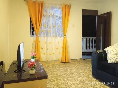 a living room with a couch and a television at Polycap Cottage Home in Murangʼa
