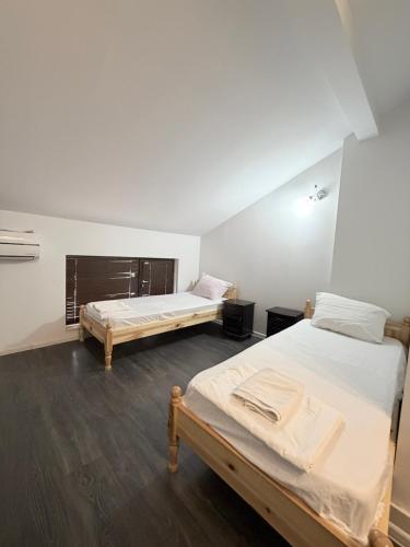 two twin beds in a room with wooden floors at Restaurant-Motel Khan Krum in Kamchiya