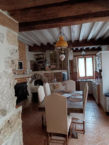 eine Küche und ein Esszimmer mit einem Tisch und einem Kamin in der Unterkunft Maison au bord de l'eau in Apremont
