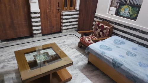 a bedroom with a bed and a table and a chair at Radha Ras Homestay in Barsāna