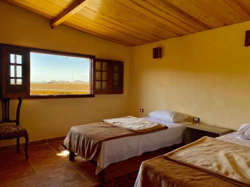 a room with two beds and a window in it at Taghaghien Island Resort in Siwa