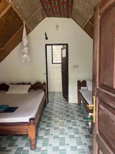 a bedroom with two beds and a open door at Olga Beach Nungwi in Nungwi