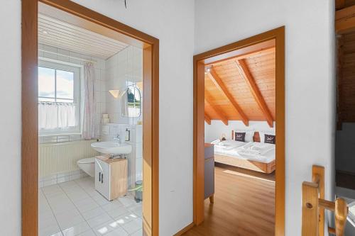 a bathroom with a sink and a bedroom with a bed at Kuschelige Ferienwohnung mit Balkon & Free Wifi in Buchenberg