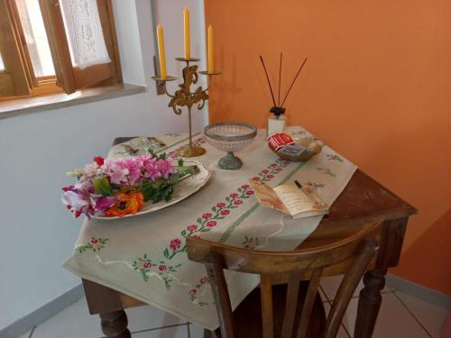 a table with a plate of flowers and candles on it at La casa dei nonni in Savignano Irpino