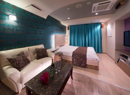 a hotel room with a couch and a bed at Hotel Antoinette -SPA RESORT- AdultOnly in Okazaki