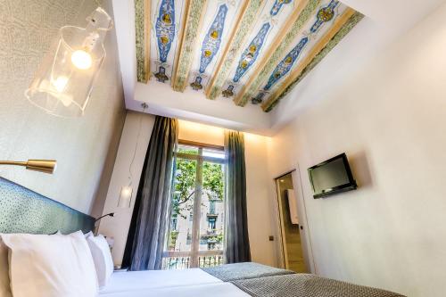 a hotel room with a bed and a window at Exe Ramblas Boquería in Barcelona