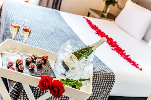 a tray of cupcakes and champagne glasses on a bed at Exe Ramblas Boquería in Barcelona