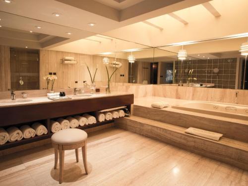 y baño con bañera, lavamanos y taburete. en Swissotel Lima, en Lima