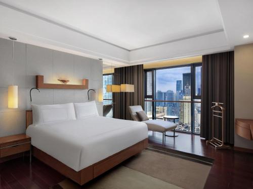 a bedroom with a large white bed and a large window at Swissôtel Grand Shanghai - Stroll down West Nanjing Road and soak in downtown Shanghai vibrancy in Shanghai