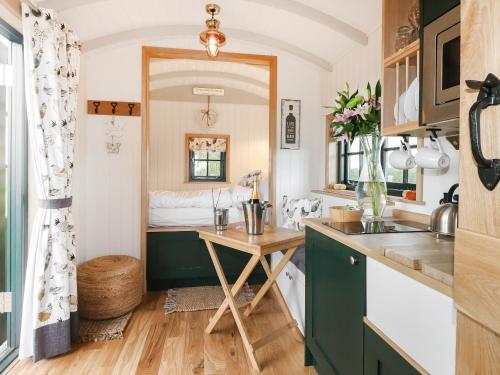 a kitchen with a desk and a bed in a room at Poppie's Shepherd Hut - Uk50227 in Redmile
