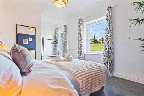 a bedroom with a large bed and a window at Haven on the Hill - FREE Parking & Great for Groups in Abertillery