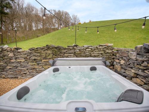 a jacuzzi tub in a stone wall at Frondeg in Capel Garmon