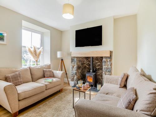 a living room with two couches and a fireplace at Frondeg in Capel Garmon