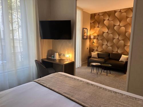 a hotel room with a bed and a couch at HOTEL ARVERNA VICHY - ClT'HOTEL in Vichy