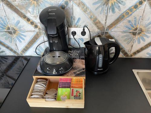 a coffeemaker and a coffee maker on a table at Nieuw Studio 16 met uitzicht op Domburg in Aagtekerke