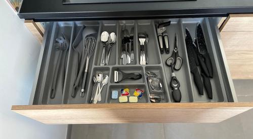 a drawer filled with utensils in a cabinet at Nieuw Studio 16 met uitzicht op Domburg in Aagtekerke