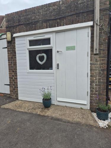 een witte garage met een raam en een deur bij 'Little Star' accommodation in Heathfield