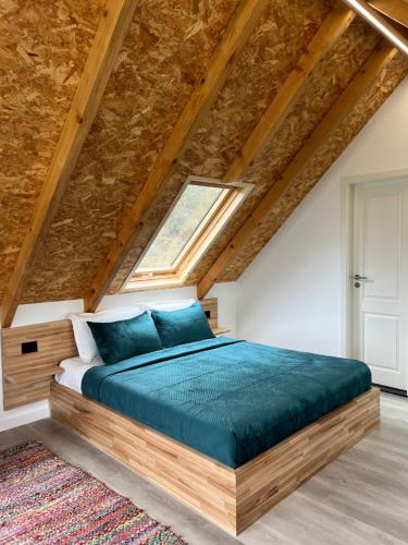 a bedroom with a large bed with blue pillows at SunnyHill Villa in Shkodër