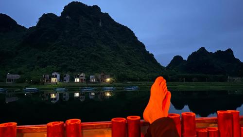 eine Person, die ihre Füße am Rand eines Gewässers hat in der Unterkunft Phong Nha Coco House in Phong Nha