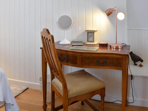 a desk with a chair and a mirror on it at Goodwood Coach House in Westhampnett