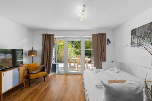 a bedroom with a bed and a tv and a couch at EG Apartment - WLAN - Terrasse - Parkplatz in Buchenberg
