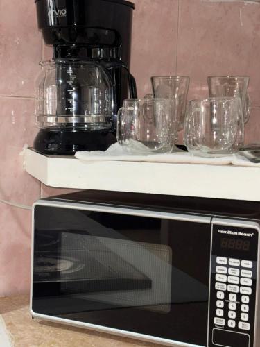 a counter with glasses on top of a microwave at The Room Veracruz, super location in Veracruz