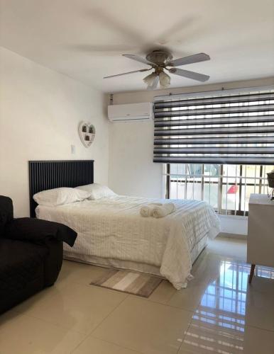 ein Schlafzimmer mit einem Bett und einem Deckenventilator in der Unterkunft The Room Veracruz, super location in Veracruz