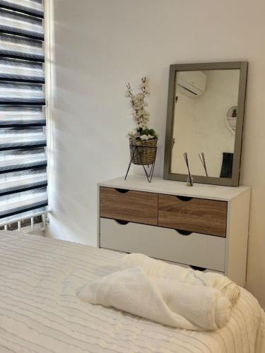 ein Schlafzimmer mit einer Kommode mit einem Spiegel darauf in der Unterkunft The Room Veracruz, super location in Veracruz