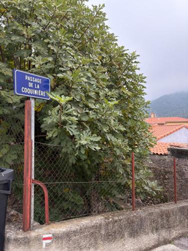 a blue sign on a fence next to a tree at CHEZ FERNAND in Arles-sur-Tech