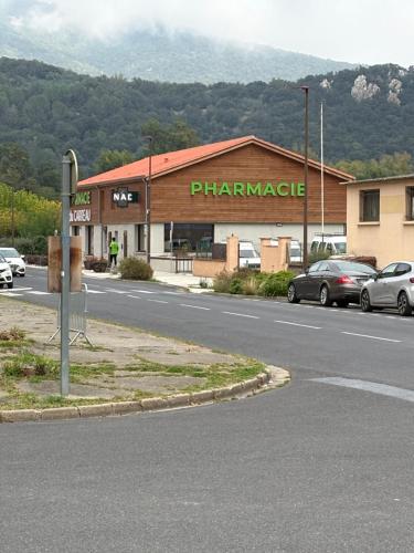 a pharmacy building with cars parked in a parking lot at CHEZ FERNAND in Arles-sur-Tech
