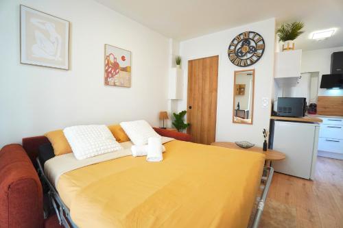 1 dormitorio con 1 cama con manta amarilla en Studio neuf parking gratuit 15 minutes de Lyon, en Francheville