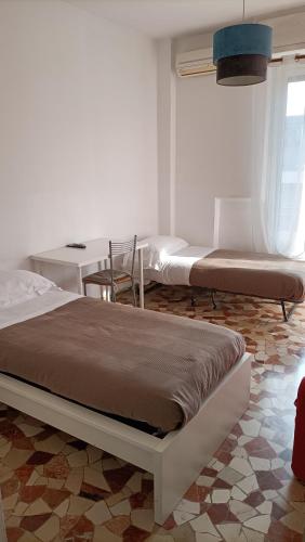 a bedroom with two beds and a table and a desk at Novegro Linate 101 in Linate