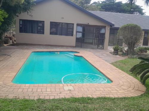 a swimming pool in front of a house at Nqabanqaba 12 in Meer en See