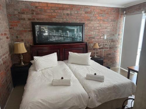 a bedroom with a large white bed with two pillows at Classic Air B&B in Pearly Beach