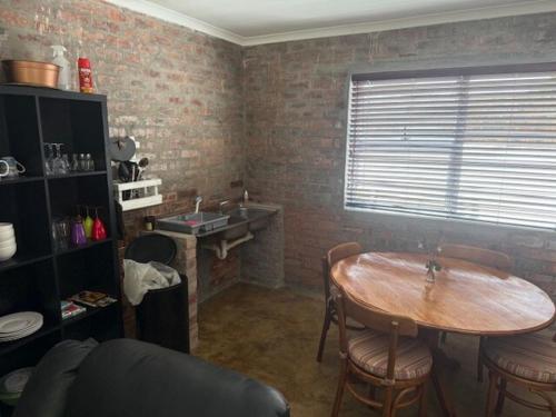 a kitchen with a table and a sink and a table and chairs at Classic Air B&B in Pearly Beach
