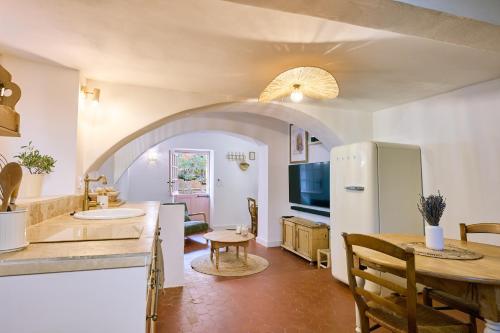 Una cocina y una sala de estar con una mesa y un refrigerador. en La Recampado, en Bormes-les-Mimosas