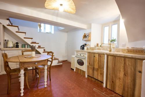 a kitchen with a table and a sink and a stairway at La Recampado in Bormes-les-Mimosas