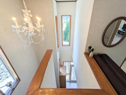 a staircase with a chandelier in a house at Minpaku ROADHOUSE - Vacation STAY 20160v in Nagasaki