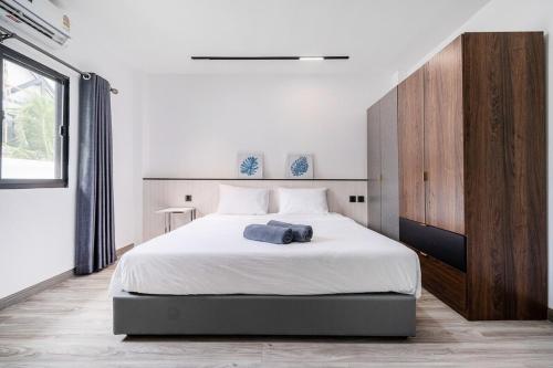 パタヤ・ノースにあるVilla 35 Wongamat 4BR, 300m from BEACHのベッドルーム1室(白い大型ベッド1台、木製キャビネット付)