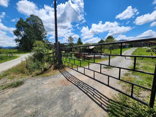 a fence on the side of a dirt road at Casa Pessegueiro in Urubici