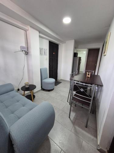 a living room with a blue couch and a table at Apartamento centro de pereira a 2 cuadras del hospital san jorge in Pereira